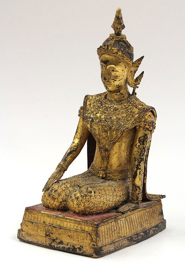 Thai Gilt Bronze Buddhist Sculpture: Thai gilt bronze Buddhist figure, 19th century, the long face topped with an ornate diadem and adorned with an elaborate collar cast with stylized blossoms, with one hand on the plinth heightened in r