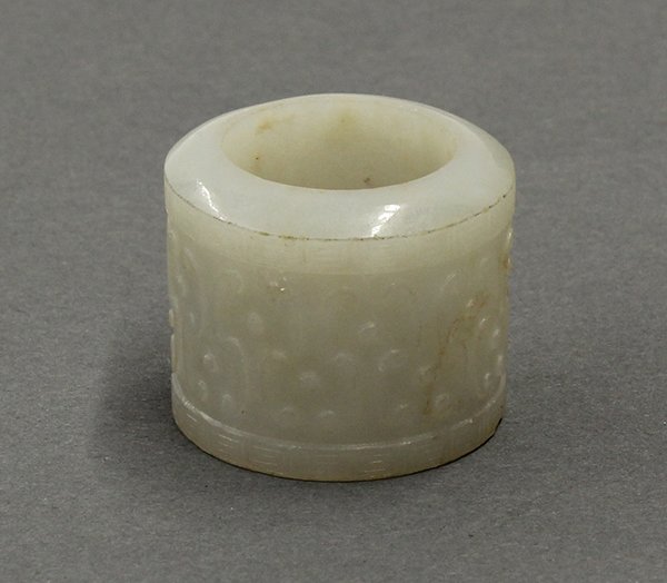 Chinese Carved Jade Thumb Ring/Archer's Ring: Chinese jade thumb ring, low relief carve with S-form scrolls and with key-fret bands accenting the edges, 1"h