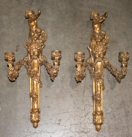 A pair of Rococo style gilt metal two light figural wall sconces
