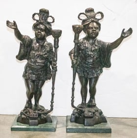 A pair of Baroque style patinated bronze figural candlesticks
