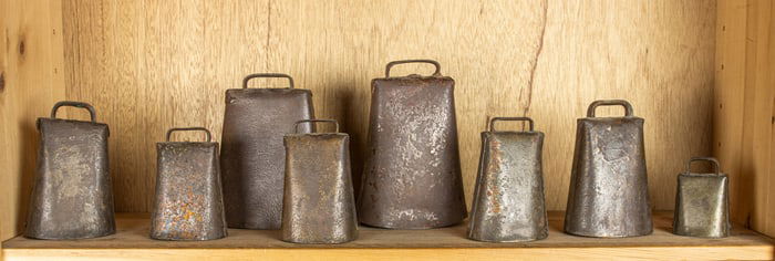 A group of eight antique iron cowbells