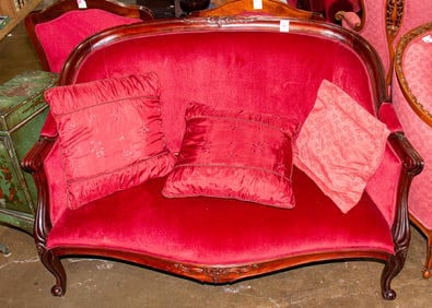 A contemporary Louis XV style mahogany sofa, with a camel back and carved crest, outswept arms, and