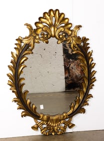 A large Baroque style parcel gilt oval mirror