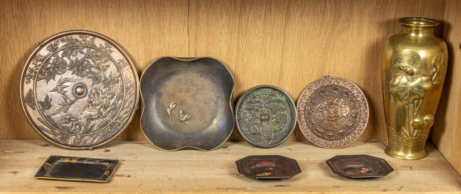 A shelf of Asian metal objects