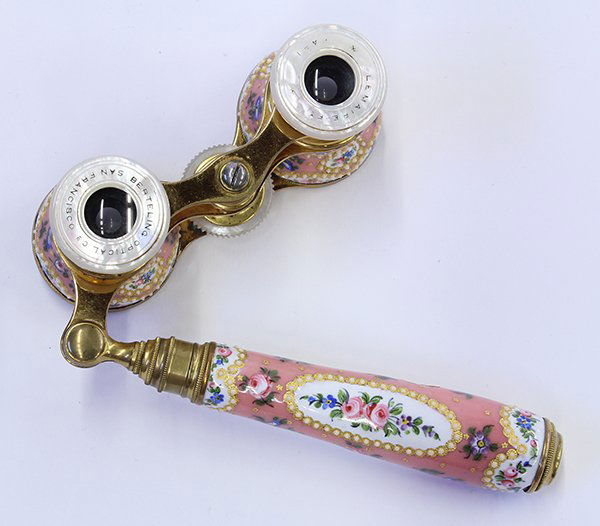 French enameled porcelain opera glasses: French enameled porcelain opera glasses, the barrels and telescopic handle decorated with jeweled floral swags and medallions on a pink ground and having mother of pearl wheel and eye pieces each mark