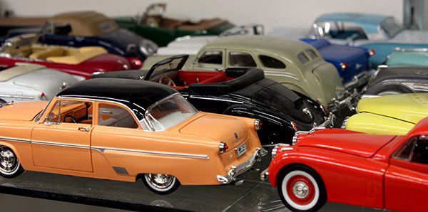 Associated group of die-cast metal model cars and truck: (lot of 25) Associated group of die-cast metal model cars and trucks with plastic bases, including 1936 Ford Pickup, 1941 Packard Darrin Convertible, 1947 Cadillac Series 62 soft top, etc., each 1:32