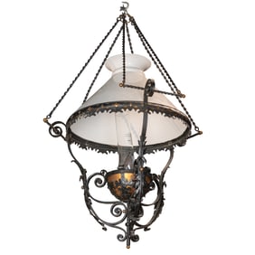 A Victorian wrought iron and copper hanging kerosene lamp with milk glass shade