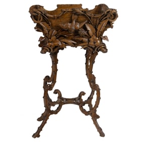 A Black Forest carved lindenwood pedestal jardiniere