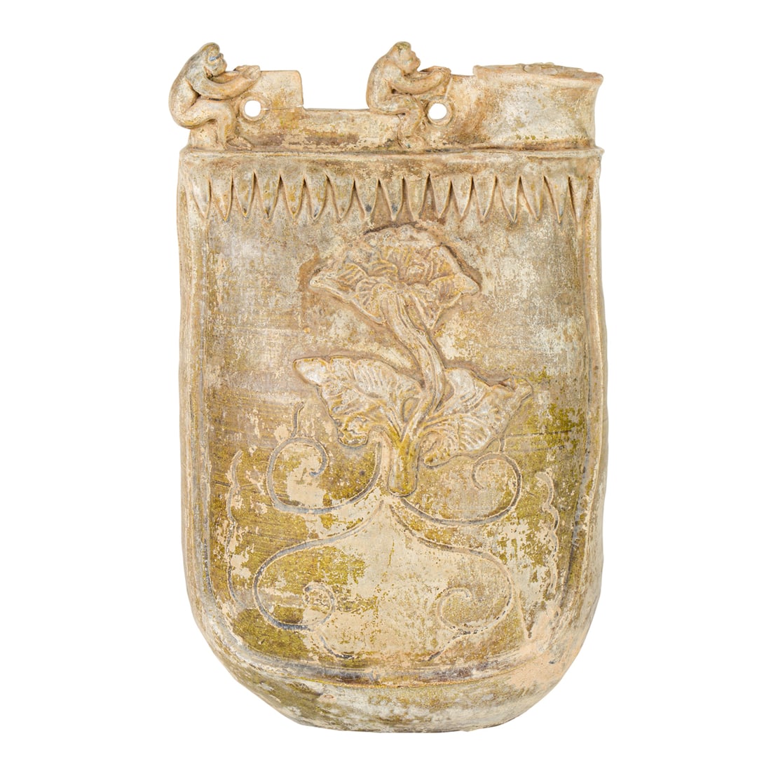 A Chinese green glazed pottery flask: A Chinese green glazed pottery flask. The flask in the form of a saddle bag, decorated with a floral relief on either side picked out in ocher glaze, the top with perforated flanges decorated with two