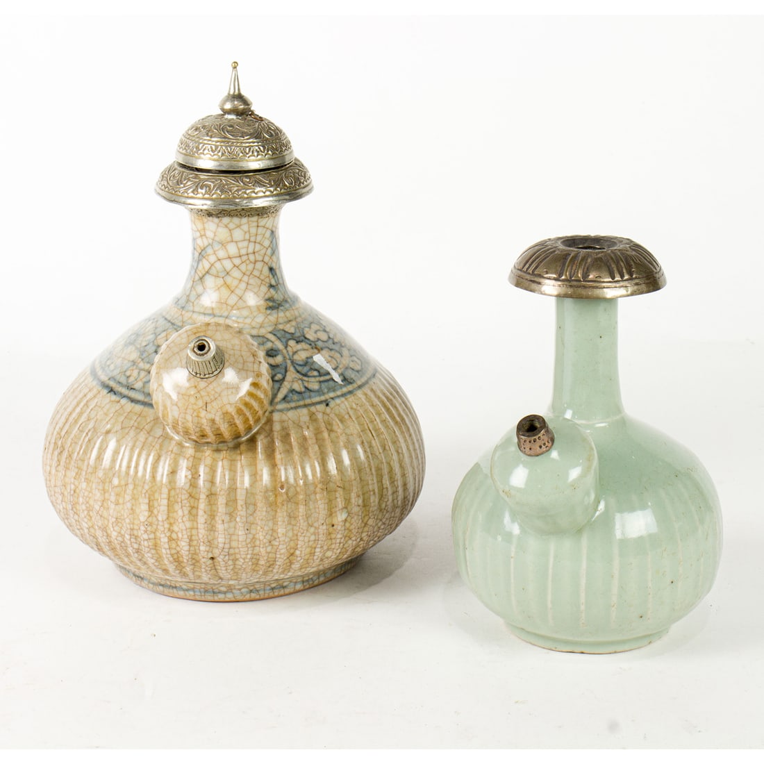 (lot of 2) Chinese porcelain kendi with silver mounts: (lot of 2) Chinese porcelain kendi with silver mounts. Comprising a blue and white kendi, and a celadon glazed kendi, late Qing period, 8.5" tallest.