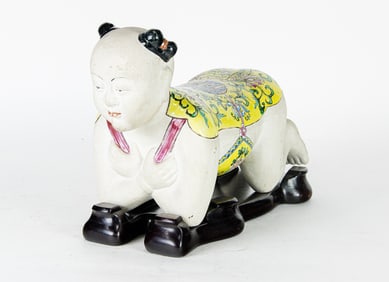 A Chinese famille rose boy headrest with stand