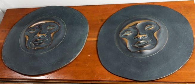 A pair of circular figural wall sculptures