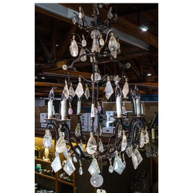 A Baroque style iron eight light chandelier hung with rock crystal pendant drops