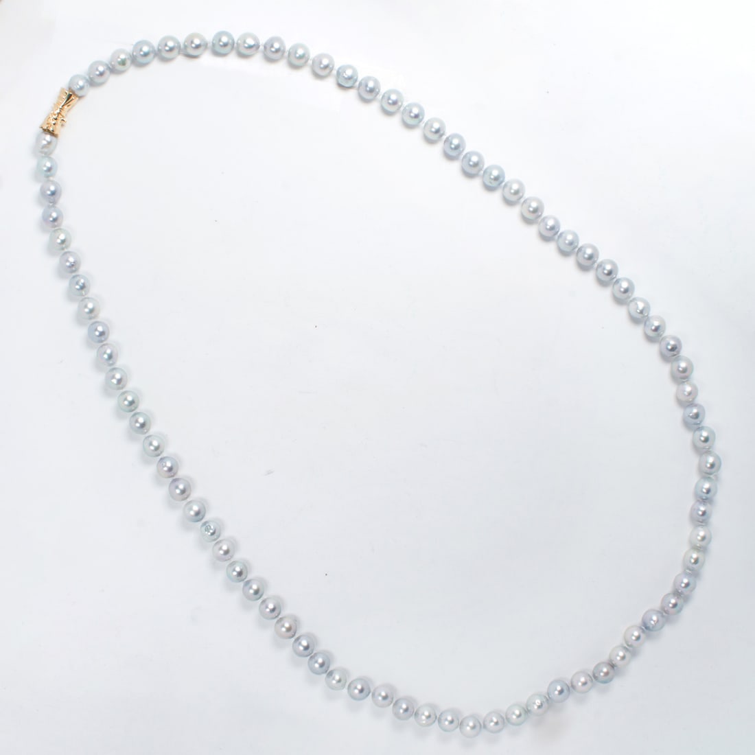 A grey baroque pearl strand: A grey baroque pearl stranddesigned as a strand of cultured, grey baroque pearls, measuring approximately 8/5 to 9 mm in diameter, joined by 14k gold fancy barrel clasp; 77.98 grams; length: 32 in
