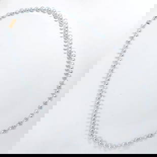 A grey baroque pearl strand: A grey baroque pearl stranddesigned as a strand of cultured, grey baroque pearls, measuring approximately 8/5 to 9 mm in diameter, joined by 14k gold fancy barrel clasp; 77.98 grams; length: 32 in