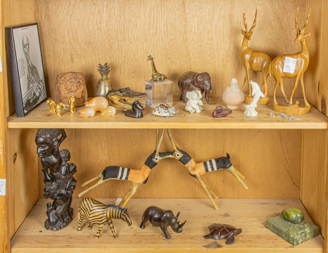 An assembled group of mainly animal figurines, including African: An assembled group of mainly animal figurines, including African, in wood, marble, brass, ceramic and stone, with a taxidermied alligator head and framed print, greatest 13.5"h {27 total]
