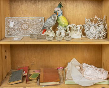 An assembled group of items including Dresden parrot figures, glass, books and others