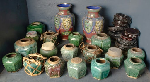 A collection of seventeen Chinese green glazed pots, two enameled vases and stands