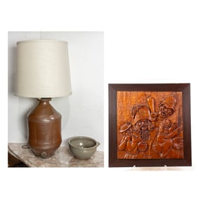 An assembled group comprised of a stoneware barrel lamp, a mixing bowl with a carved wooden plaque