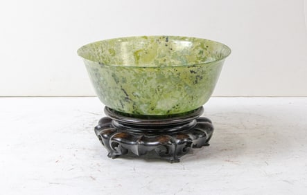 A Chinese green hardstone bowl and wood stand