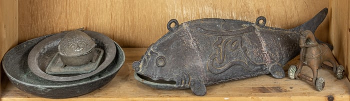 A shelf of Asian metal decorative objects
