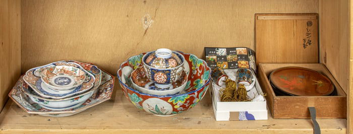 A shelf of Japanese Imari items and other decorative objects