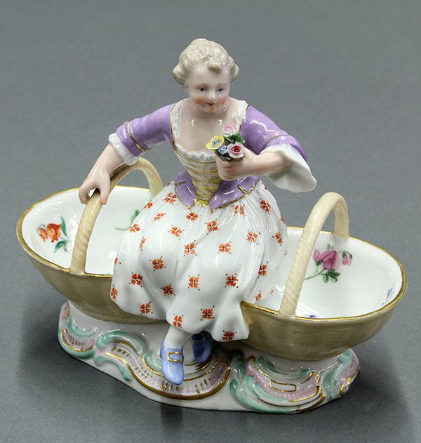 Meissen figural double salt: Meissen figural double salt, modeled as young girl flanked by two baskets, atop a rocaille base, underglaze blue crossed swords mark, incised marks, 5"h x 6"w