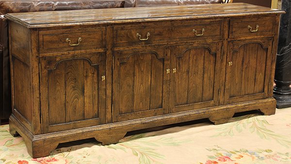 English Provincial style sideboard: English Provincial style sideboard, the rectangular top above a four door case accented with panelled doors and rising on bracket feet, 31"h x 73"w x 18"d Provenance: Property from the Estate of Frank