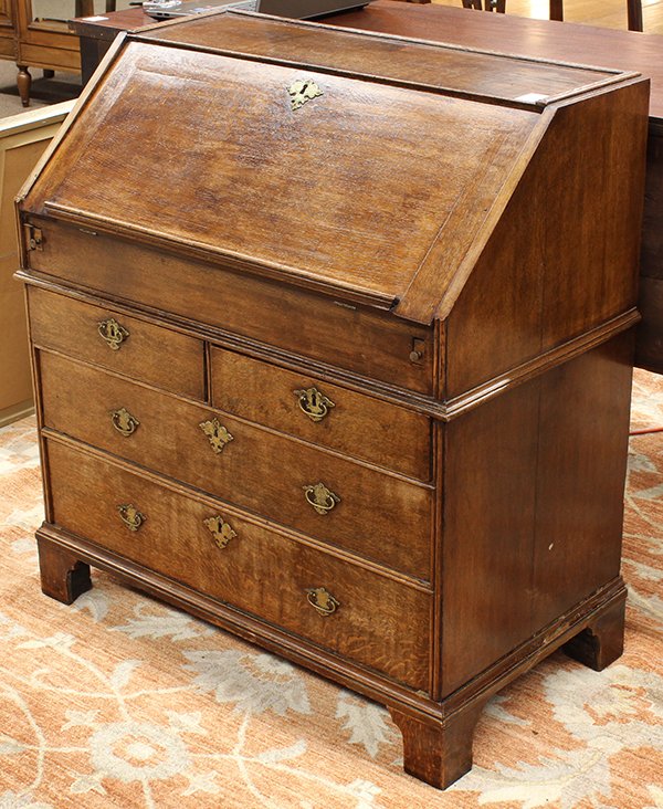 Georgian slant front desk: Georgian slant front desk, executed in quartersawn oak circa 1730, the fall front opening to a fitted interior centering the slide back open compartment, the lower case with four drawers retaining per