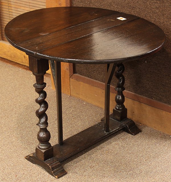 Drop leaf pub table, executed in oak and having barley : Drop leaf pub table, executed in oak and having barley twist supports terminating at the lower tier and rising on shoe feet, 26"h x 22"w x 33"d (extended)
