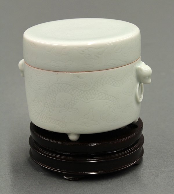 Chinese Celadon Glazed Porcelain Container, Dragon: Chinese celadon glazed porcelain covered container, the exterior incised with meandering dragons amid clouds in pursuit of sacred jewels, the cylindrical box flanked by zoomorphic handles suspending m