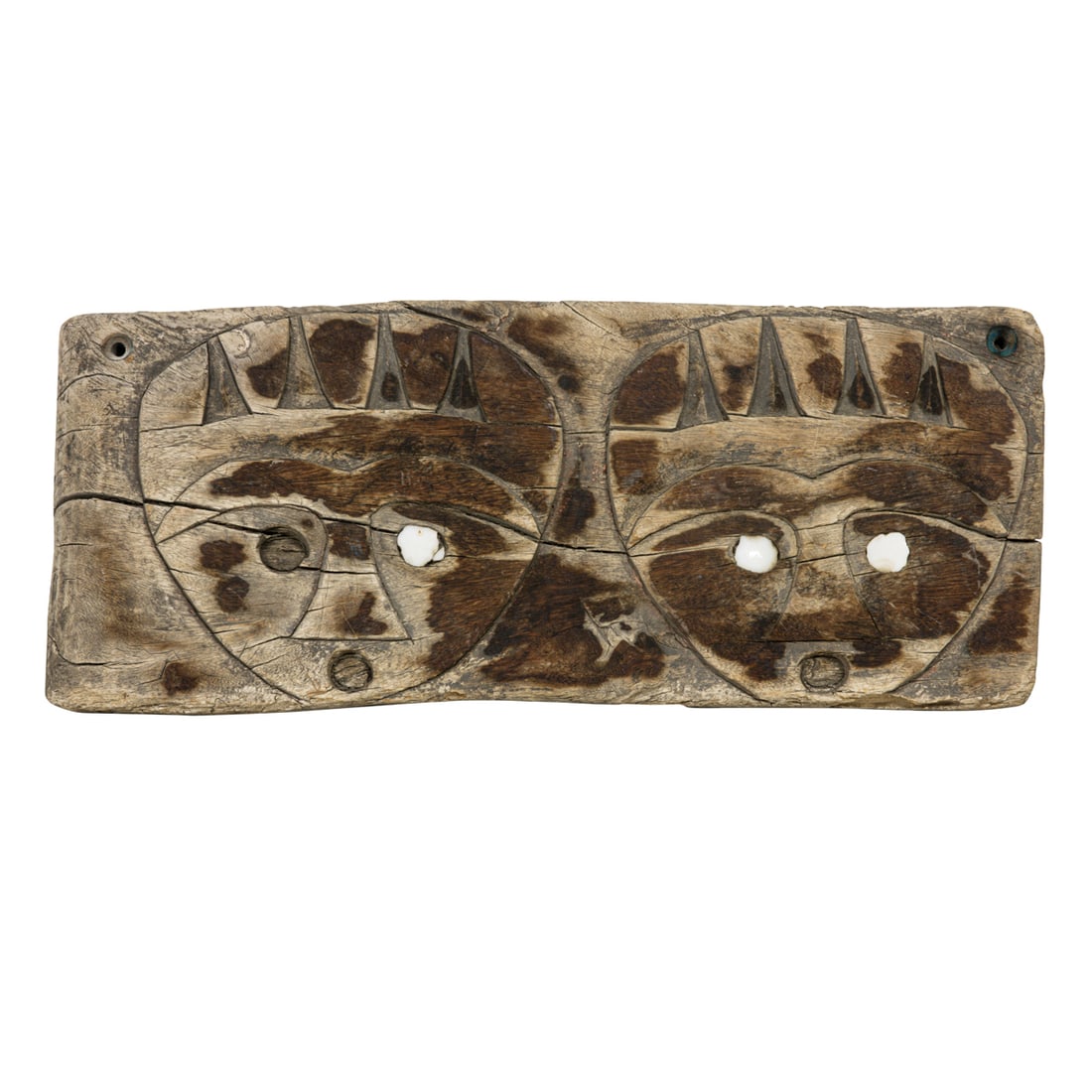 A Paiwan double-face wood panel with shell inlaid eyes: A Paiwan double-face wood panel with shell inlaid eyes. 6"h x 14.75"w. Provenance: Naomi Lindstrom