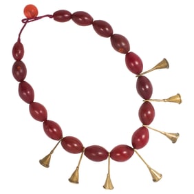 An Ao Naga dark red glass bead necklace with trumpet shaled brass pendants