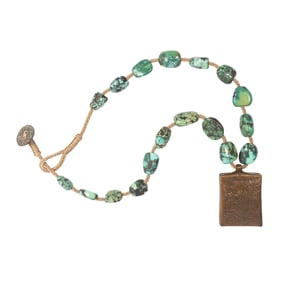A strand of antique Tibetan turquoise beads with copper Ganesh pendant
