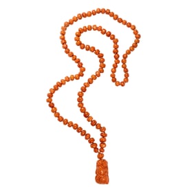 A Sino-Tibetan red coral bead necklace and toggle pendant