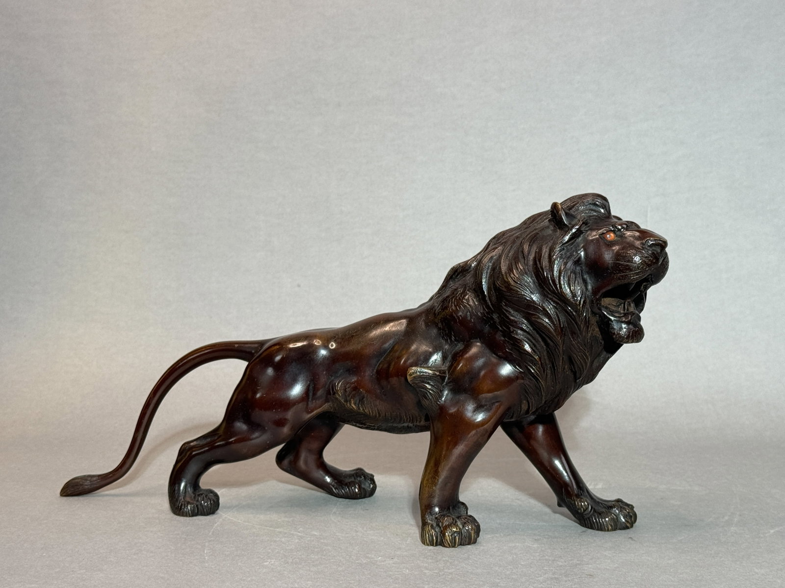 Japanese Bronze Lion, Meiji Period: Japanese Meiji period bronze lion, with glass inlay eye, artist signature with single character on two front paw. 9"h x 16.5"w (22.86 x 41.91cm) NOTE: THIS ITEM IS IN NEW YORK, WHERE IT CAN BE SHIPPED