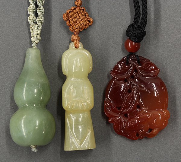 Three Chinese Jade Toggles, Gourd, Figure and Fruits: (lot of 3) Group of Chinese jade and stone toggles, the first a carnelian carved with a rabbit seated below a cluster of fruits; the second a celadon hue jade double gourd; the third, a yellow jade ca