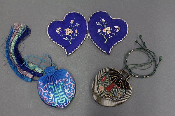 Three Chinese Satchels and Ear Muffs: (lot of 3) Chinese embroidered satchels/pouches and pair of ear muffs, late Qing/Republic period: the first a satchel woven with the character 'shou' amid a wanzi pattern; the second a blue satchel em