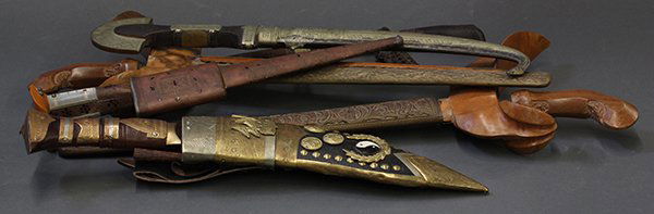 Middle Eastern and Asian knives with sheaths: (lot of 7) Middle Eastern and Southeast Asian knives with sheaths including Indonesian krisses, Nepalese dagger, and an associated red velvet sheath having beaded embroidery.