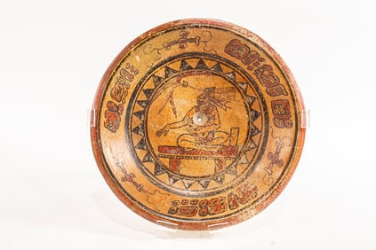 A Mayan plate depicting a priest on throne