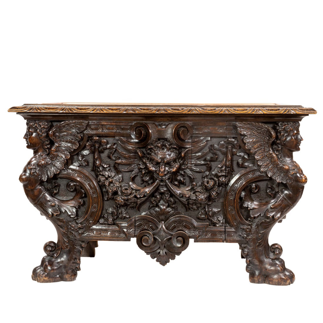 A Continental carved console table in the Renaissance taste circa 1860: A Continental carved console table in the Renaissance taste circa 1860, the highly carved case with a mythological figural center medallion flanked by the two winged females and rising on carved feet,