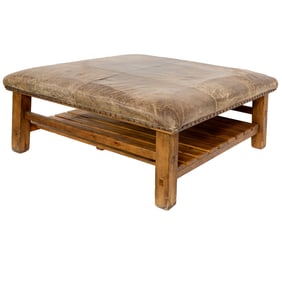 A large contemporary distressed ottoman with nailhead trim
