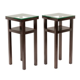 A pair of contemporary patinated metal pedestal side tables with glass top