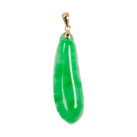 A carved jade and 14k gold pendant