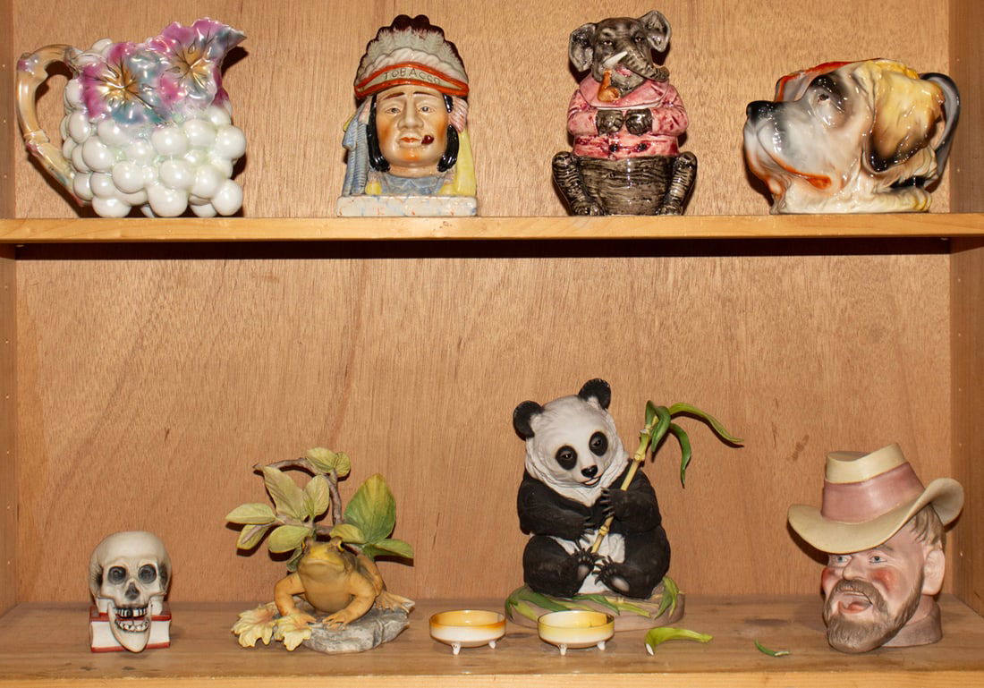 A group of Royal Bayreuth and other ceramics: A group of Royal Bayreuth and other ceramics, including Japanese bisque nodding skull; majolica elephant tobacco jar; majolica chief tobacco jar; Royal Bayreuth porcelain Saint Bernard dog pitcher, Bo