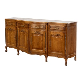 A large French buffet circa 1900, executed in oak with a serpentine four door case, a parquetry top,