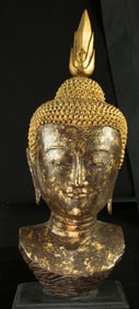 A Southeast Asian gilt lacquered wood bust of Buddha on a wood stand