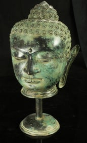 A Southeast Asian bronze head of Buddha on a bronze stand