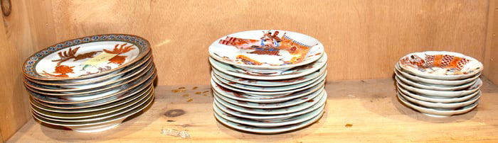 A shelf of Chinese and Japanese enameled porcelain dishes