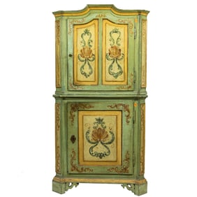 A Continental paint decorated corner cabinet